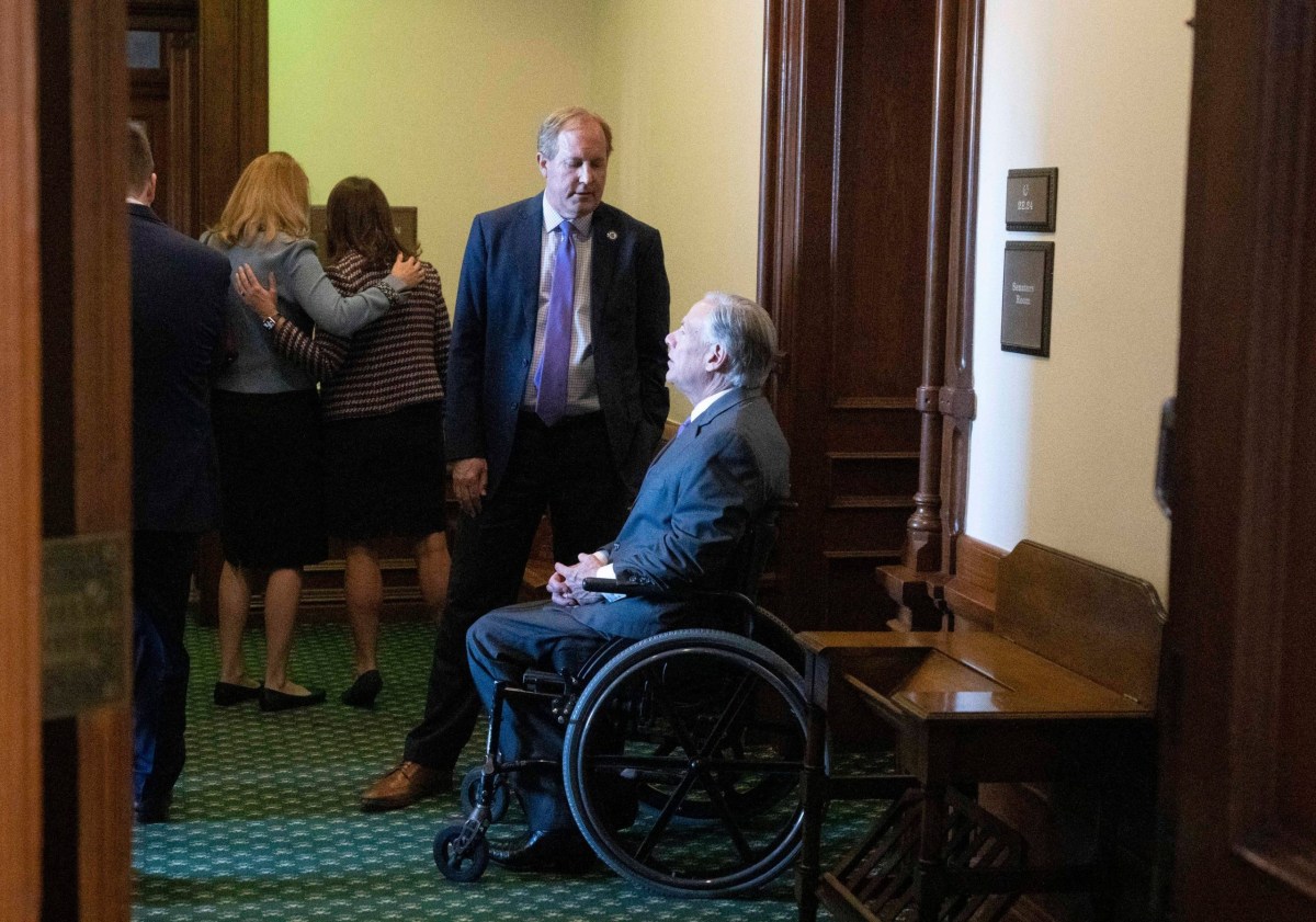 Attorney General Ken Paxton confers with Gov. Greg Abbott outside the Senate chamber before his swearing-in ceremony on Jan. 10, 2023.