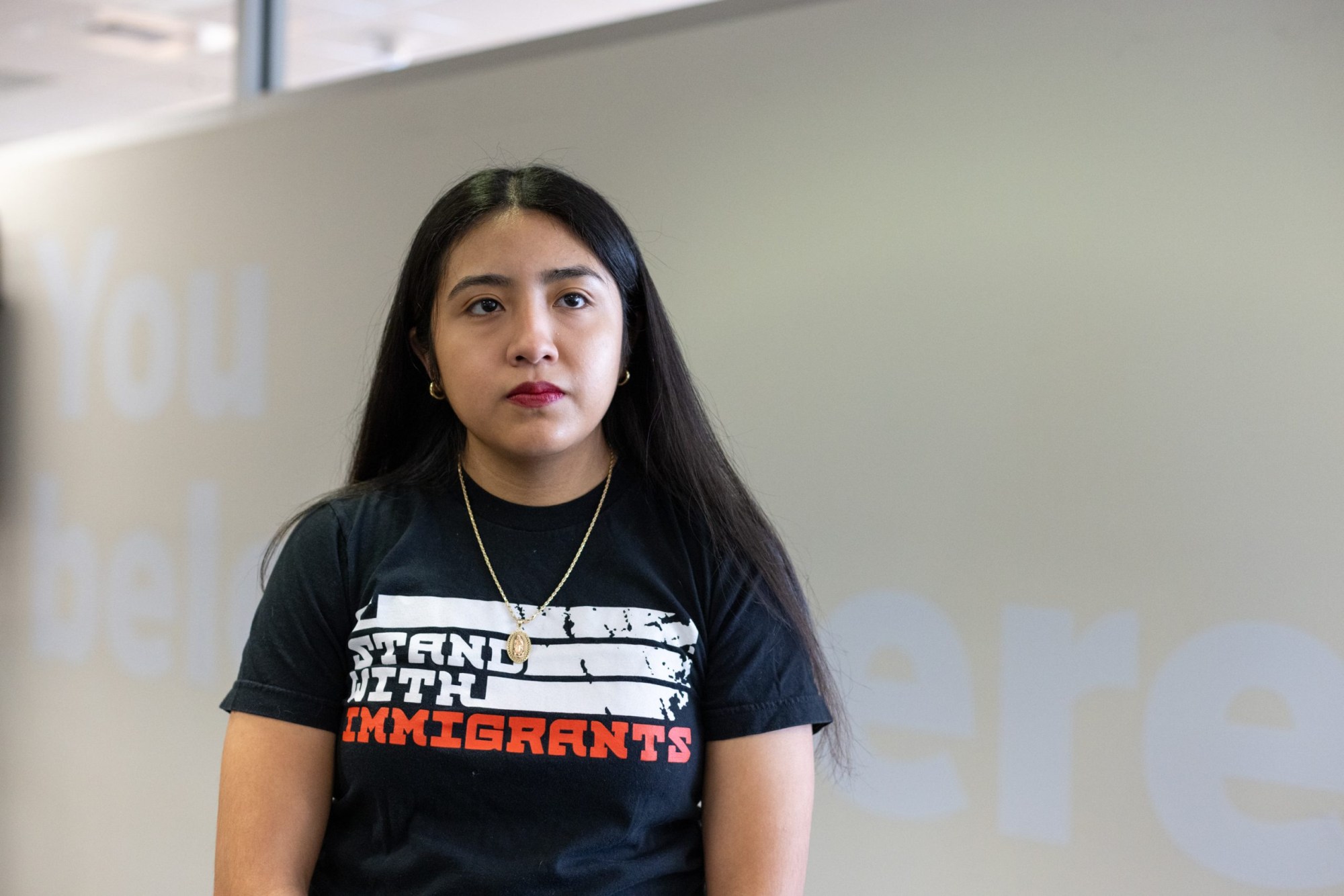 Victoria Uriostegui at the Student Services Building at the University of Texas at Austin on Feb. 20, 2024. The wall behind them reads, 