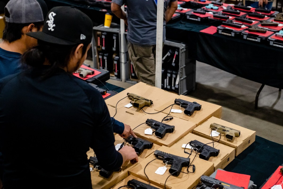 Patrons of the SAXET Gun Show look at handguns at the Richard M. Borchard Regional Fairgrounds in Robstown on Feb. 26, 2023.
