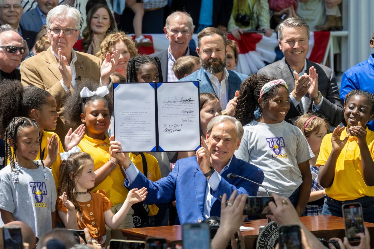 Gov. Greg Abbott signs legislation authorizing a private school voucher program into law at the Texas Governor’s Mansion in Austin on May 3, 2025.