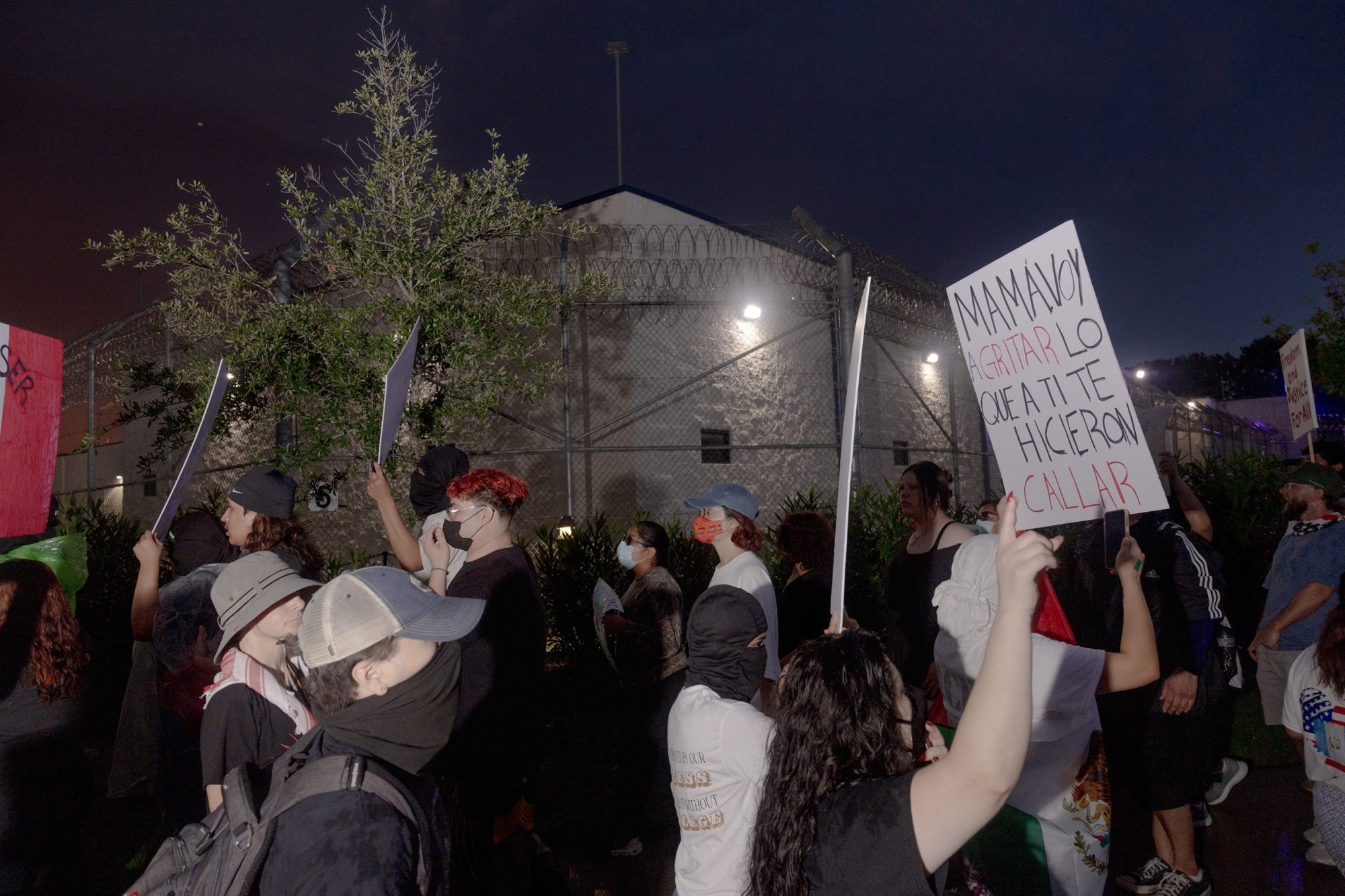 People chant and wave flags during the protest outside of the Core Civic Processing Center.
