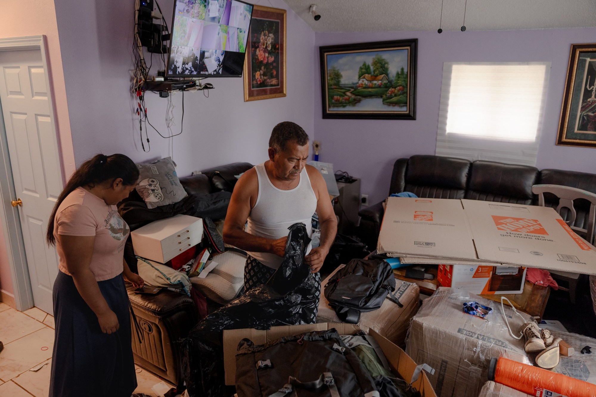 José Avila packs up boxes to send belongings to his wife, Margarita, who has been sent to her home country of Belize after signing her deportation papers, in June.