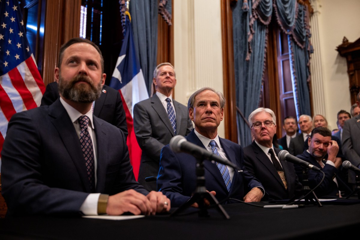From left, House Speaker Dustin Burrows, Gov. Greg Abbott and Lt. Gov. Dan Patrick hold a bill signing ceremony at the Texas Capitol on April 23, 2025 to create a Texas Department of Government Efficiency.