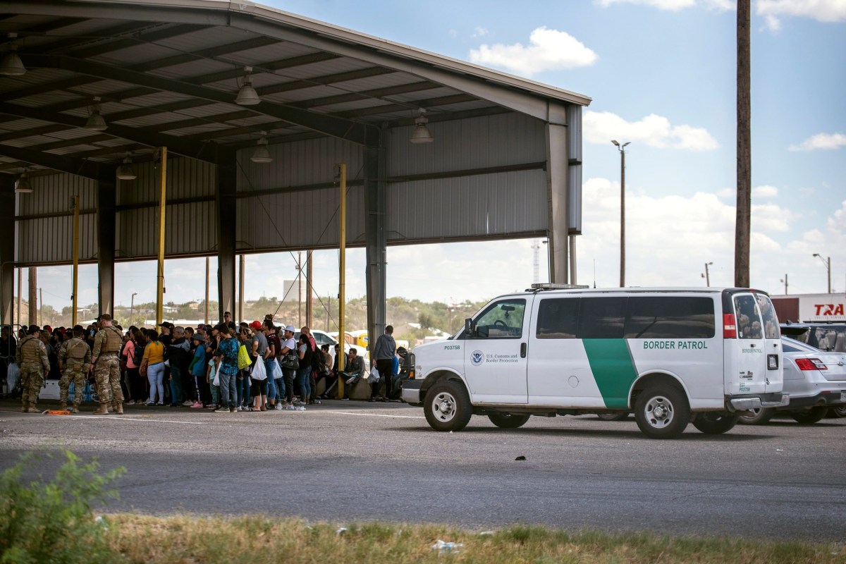 Migrants apprehended by state troopers after crossing the Texas-Mexico border are brought to the International Bridge in Eagle Passand handed over to Border Patrol custody on May 28, 2022.