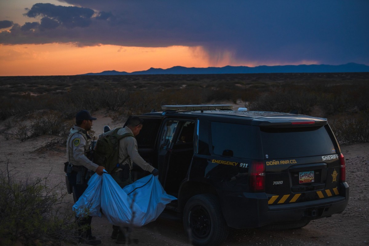 Doña Ana County Sheriff Deputy N. Al-Abayad, left, and Detective Alan Barbosa transport a body bag containing the bones of a migrant, first found by volunteers with Battalion Search and Rescue, on May 3, 2025. The discovery of migrant bodies in the desert has spiked since El Paso joined Texas’ Operation Lone Star.