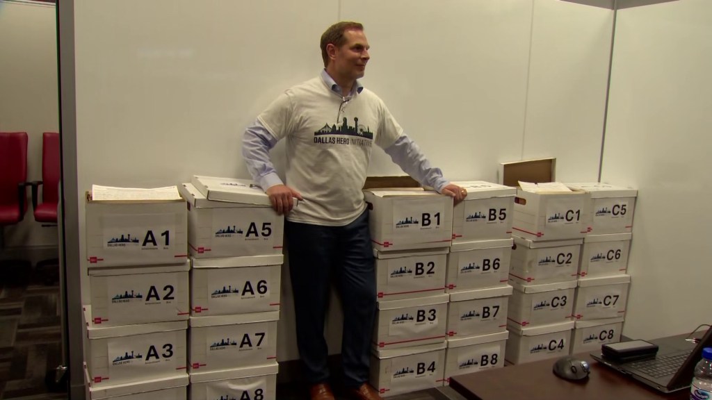Pete Marocco stands beside boxes of signatures used to get the Dallas HERO propositions, aimed at changing the Dallas city charter, on the November 2024 ballot.